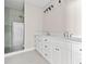 Bathroom features double vanity, marble countertop, white cabinets, and a tiled shower with glass door at 52 Lake Overlook Dr, White, GA 30184