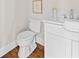 Cozy half bathroom with white vanity, framed artwork, and hardwood flooring at 52 Lake Overlook Dr, White, GA 30184