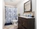 Bathroom featuring vanity with sleek faucet and a tiled shower with decorative curtain at 6540 Muirfield Pt, Fairburn, GA 30213