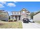 Charming two-story home features a stone facade, covered porch, manicured lawn, and a two-car garage at 6540 Muirfield Pt, Fairburn, GA 30213