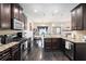 Modern kitchen features stainless steel appliances, granite countertops, and dark wood cabinets at 6540 Muirfield Pt, Fairburn, GA 30213