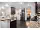 Modern kitchen featuring granite countertops, stainless steel appliances, and dark wood cabinetry at 6540 Muirfield Pt, Fairburn, GA 30213