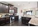 Modern kitchen features stainless steel appliances, granite countertops, and dark wood cabinets at 6540 Muirfield Pt, Fairburn, GA 30213
