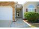 Inviting entrance of home featuring manicured landscaping, stone walkway, and two-car garage at 681 Nine Oaks Cir, Villa Rica, GA 30180