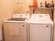Functional laundry room with washer, dryer, and shelving at 681 Nine Oaks Cir, Villa Rica, GA 30180