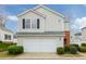 Charming two-story home with a white garage door and well-manicured landscaping at 102 Manley Ct, Woodstock, GA 30188