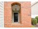 Welcoming front entrance with a classic black door framed by brick columns and manicured bushes at 102 Manley Ct, Woodstock, GA 30188