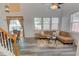 Bright living room featuring high ceilings, a ceiling fan, a dining table, and large windows with charming curtains at 102 Manley Ct, Woodstock, GA 30188
