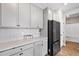 Charming kitchen featuring white cabinetry, stone countertops, herringbone backsplash and stainless steel appliances at 1052 Bodega Loop, Locust Grove, GA 30248