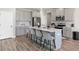 Stylish kitchen boasting an island with barstool seating, gray cabinets, and stainless steel appliances at 1052 Bodega Loop, Locust Grove, GA 30248