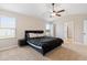 Bright bedroom featuring a dark bed frame, ceiling fan, and plenty of natural light from the large windows at 1052 Bodega Loop, Locust Grove, GA 30248
