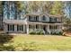 Traditional two-story home featuring a welcoming front porch and black shutters, surrounded by a well-manicured lawn at 3227 Heritage Way, Buford, GA 30519