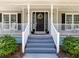 Charming front porch with gray steps and a black front door adorned with a wreath at 3227 Heritage Way, Buford, GA 30519