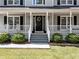 Inviting front porch with black door, white railings, and manicured landscaping at 3227 Heritage Way, Buford, GA 30519