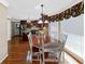 Eat-in kitchen boasts a wood table with white chairs and a window with floral valance at 3227 Heritage Way, Buford, GA 30519