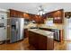Kitchen boasts stainless appliances, wood cabinets, and center island with granite counters at 3227 Heritage Way, Buford, GA 30519