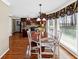 Eat-in kitchen boasts a wood table with white chairs and a window with floral valance at 3227 Heritage Way, Buford, GA 30519