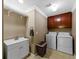 Well-equipped laundry room with sink, storage cabinet, washer and dryer units at 3227 Heritage Way, Buford, GA 30519