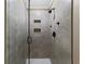 Elegant walk-in shower featuring gray tile, a glass door, and built-in niche shelving at 3227 Heritage Way, Buford, GA 30519