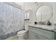 Bright bathroom featuring a round mirror, modern vanity, and a shower with a patterned curtain at 5660 Trout Creek Dr, Douglasville, GA 30135