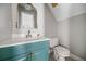 Cozy bathroom with a corner sink, vintage mirror, and a toilet, featuring a blue vanity at 5660 Trout Creek Dr, Douglasville, GA 30135