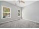 Neutral bedroom with plush carpeting, two windows allowing natural light, and a ceiling fan at 5660 Trout Creek Dr, Douglasville, GA 30135