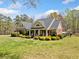 Charming brick home featuring a well-manicured lawn, lush landscaping, and inviting front porch with rocking chairs at 5660 Trout Creek Dr, Douglasville, GA 30135