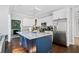 Modern kitchen featuring a large island with seating, stainless steel appliances, and sleek white cabinetry at 5660 Trout Creek Dr, Douglasville, GA 30135