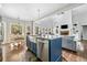 Open concept kitchen with island, stainless appliances, and view into the living room with fireplace at 5660 Trout Creek Dr, Douglasville, GA 30135