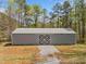 Large outbuilding/barn with a metal roof, sliding doors, and ample space for storage or hobbies at 5660 Trout Creek Dr, Douglasville, GA 30135