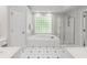 Bright bathroom showcasing a soaking tub with glass block window and a separate glass door shower at 710 Greystone Ne Park, Atlanta, GA 30306