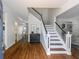 Elegant foyer with hardwood floors, a staircase with black and white accents, and an open view to the living areas at 710 Greystone Ne Park, Atlanta, GA 30306