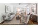 Bright and airy living room with hardwood floors, neutral furniture, and an open floor plan to the kitchen at 710 Greystone Ne Park, Atlanta, GA 30306