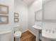 Stylish powder room with hardwood floors, a pedestal sink, and modern floral artwork at 710 Greystone Ne Park, Atlanta, GA 30306