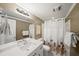 Well-lit bathroom featuring a shower with curtain, white vanity, and updated hardware and fixtures at 710 Greystone Ne Park, Atlanta, GA 30306