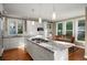 Bright and spacious kitchen featuring white cabinets, granite countertops, a large island with a cooktop, and a dining area at 710 Greystone Ne Park, Atlanta, GA 30306