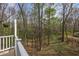 View of the backyard trees from the home's outdoor deck with white railing at 1007 Springharbor Walk, Woodstock, GA 30188