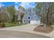 Inviting blue home featuring a two-car garage and a well-kept lawn at 1007 Springharbor Walk, Woodstock, GA 30188