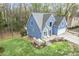 Stylish two-story blue home featuring a stone patio and well-maintained lawn at 1007 Springharbor Walk, Woodstock, GA 30188