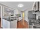 Open kitchen features hardwood floors, granite counters, stainless appliances, and bar seating at 1007 Springharbor Walk, Woodstock, GA 30188