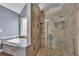 Shower with stone tile surround, built-in niche and frameless glass doors, adjacent to soaking tub at 1007 Springharbor Walk, Woodstock, GA 30188