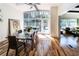 Sunlit dining area with modern table and floor-to-ceiling windows, seamlessly flowing into the living room space at 1428 Brook Valley Ne Ln, Atlanta, GA 30324