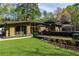 A mid-century modern home with manicured landscaping, backyard, and a deck with a pool at 1428 Brook Valley Ne Ln, Atlanta, GA 30324