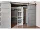 Walk-in closet with shelving, grey sliding barn doors and hardwood floors at 3235 Roswell Ne Rd # 801, Atlanta, GA 30305