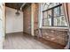 Hallway showcasing exposed brick, hardwood floors and a large window at 3235 Roswell Ne Rd # 801, Atlanta, GA 30305