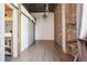 Hallway featuring sliding barn doors, hardwood floors and exposed brick details at 3235 Roswell Ne Rd # 801, Atlanta, GA 30305