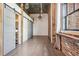 Hallway featuring hardwood floors, exposed brick and grey sliding barn doors at 3235 Roswell Ne Rd # 801, Atlanta, GA 30305