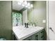 Stylish bathroom with a green vanity, modern sink, and elegant mirror with decorative lighting at 3385 Huntington Ct, Douglasville, GA 30134