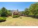 Expansive backyard featuring a deck, fire pit, and lush green lawn at 3540 Owl Brow Ct, Cumming, GA 30028