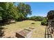 Spacious backyard with a fire pit, garden beds, and a partial view of the deck at 3540 Owl Brow Ct, Cumming, GA 30028